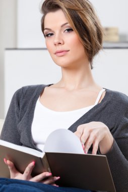 çekici kadın kanepede oturan kitap okur