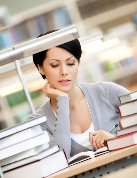 Mujer interesada lee en la biblioteca —  Fotos de Stock