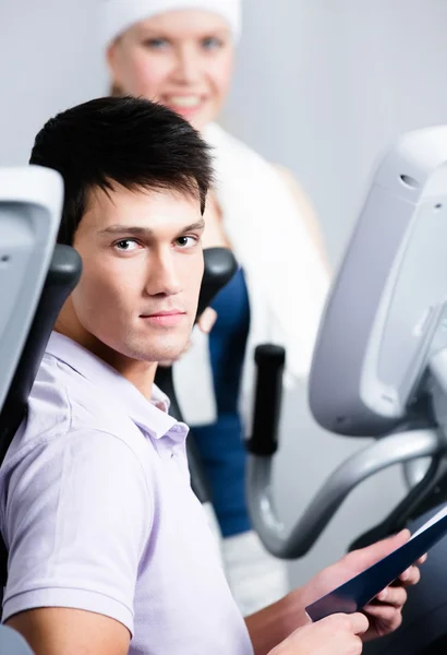 Woman training on training apparatus in gym with coach — Stock Photo, Image