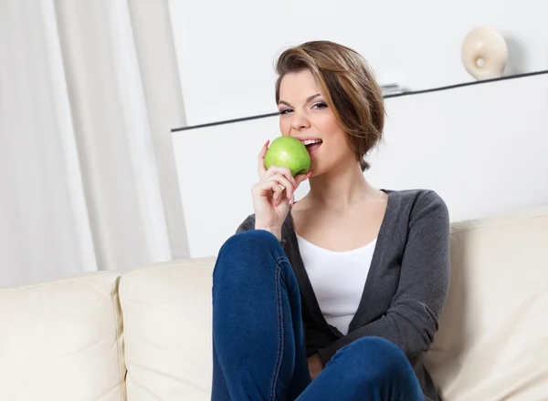 Ελκυστική γυναίκα τρώει ένα πράσινο μήλο — Φωτογραφία Αρχείου