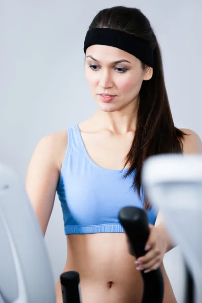 Sportiga kvinnan träning på gymutrustning i gym — Stockfoto