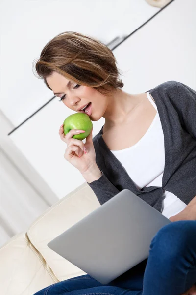 Hermosa mujer come una manzana verde Imágenes de stock libres de derechos