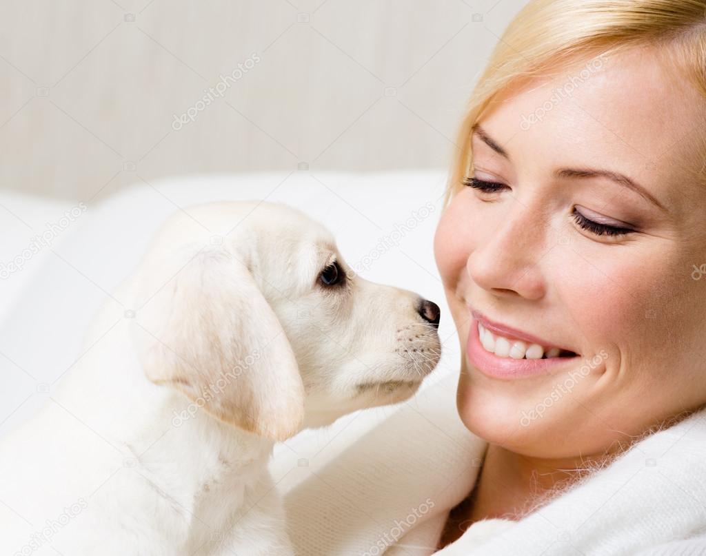 Labrador puppy and woman look at each other
