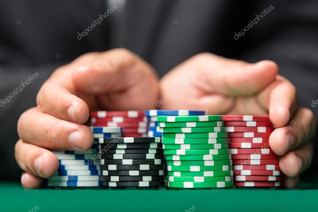 Gambler going "all in" pushing his chips forward Stock Photo by