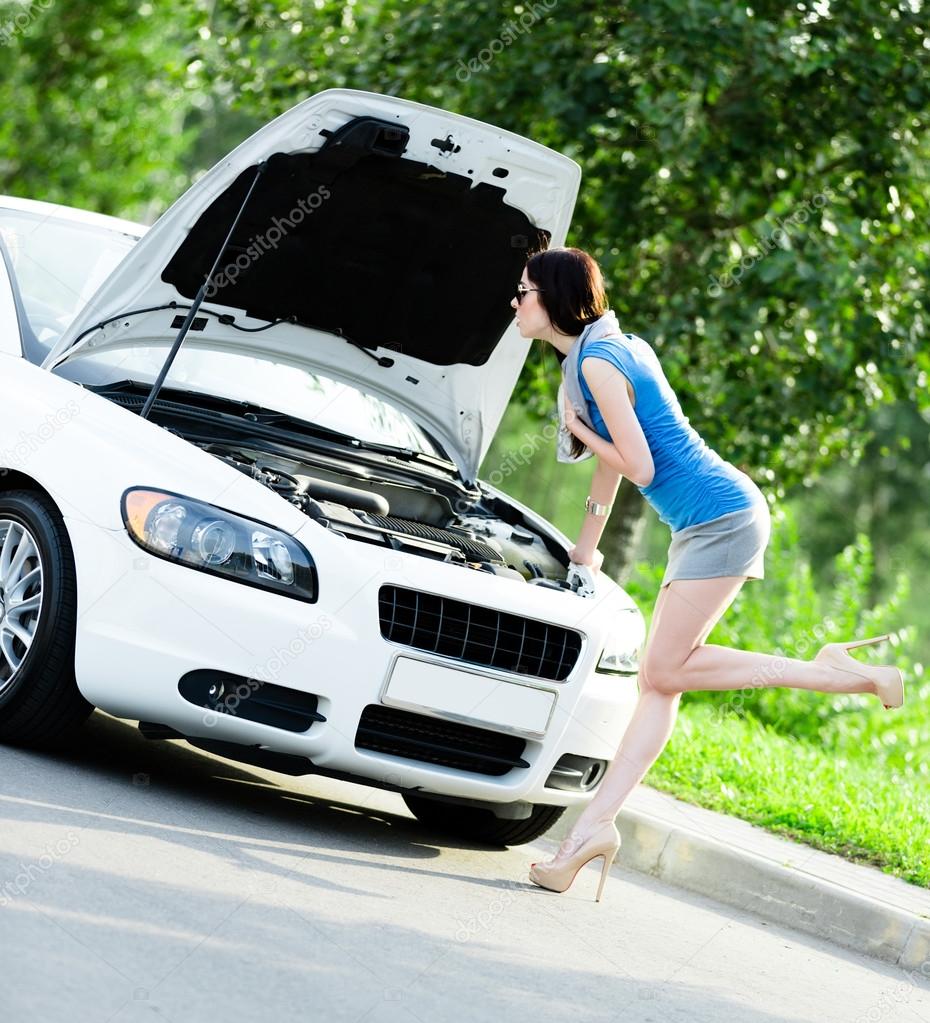 Woman repairing the broken white car
