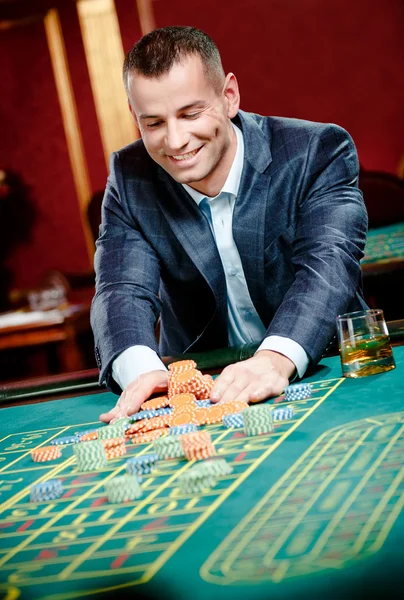 Gambler stakes pile of chips at the casino — Stock Photo, Image