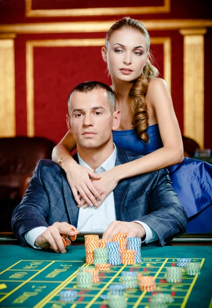 Girl embracing gambler at the casino table — Stock Photo, Image