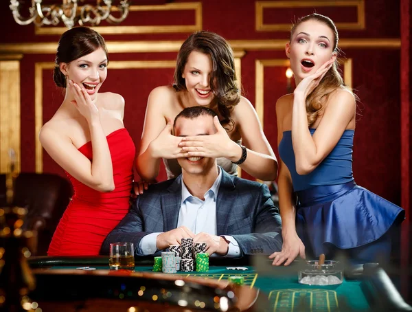 Girls cover the eyes of the gambler — Stock Photo, Image