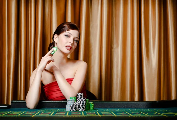 Jogadora feminina sentada na mesa de roleta — Fotografia de Stock