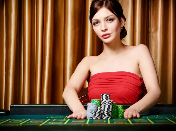 Woman bets pile of chips playing roulette — Stock Photo, Image