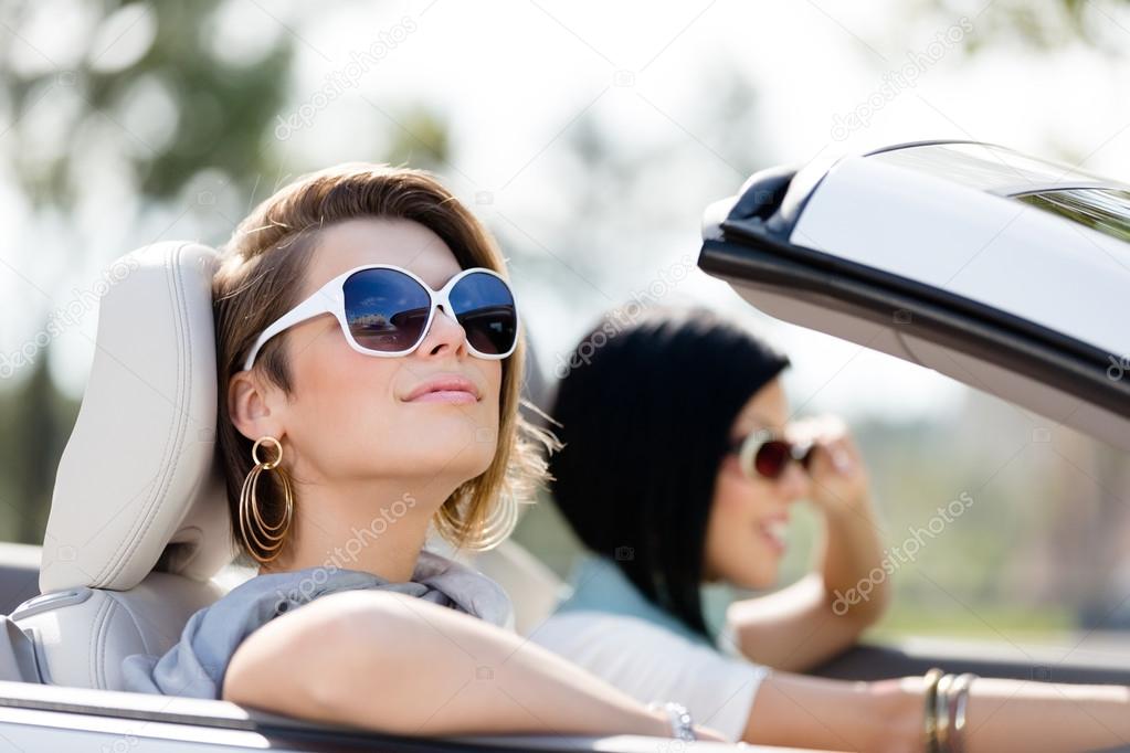 Close up of girls in sunglasses in the white car