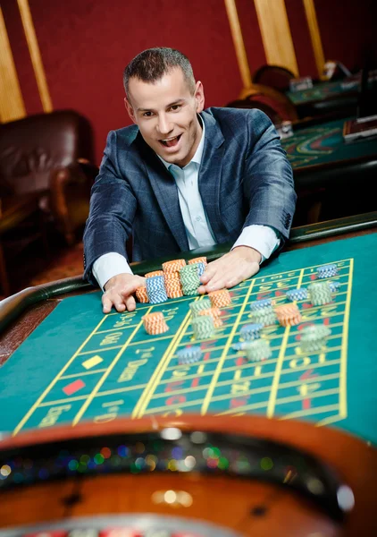 Joyful gambler stakes playing roulette — Stock Photo, Image