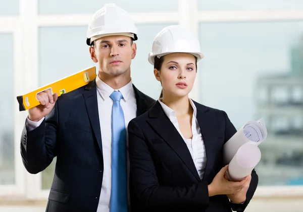 Two contractors keeping level and blueprints — Stock Photo, Image