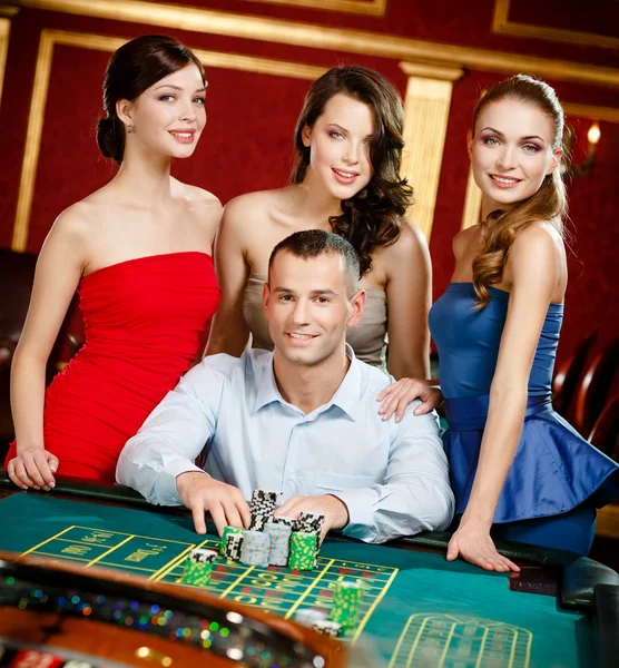 Чоловік, оточений дівчатами грає в рулетку — стокове фото
