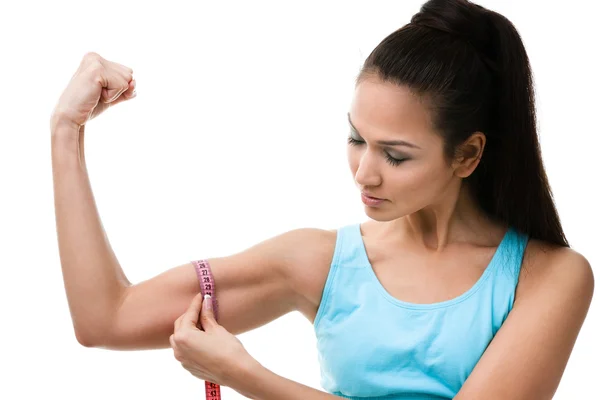 Mujer deportiva mide su bíceps — Foto de Stock