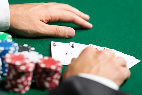 Pokerspieler öffnet seine Pokerkarten — Stockfoto