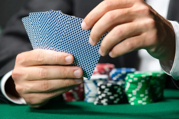 Giocatore che gioca a carte da poker con fiches sul tavolo da poker — Foto Stock
