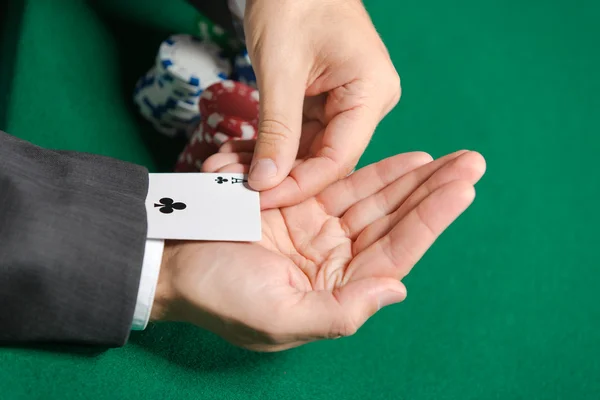 Poker player cheats with playing card from the sleeve — Stock Photo, Image