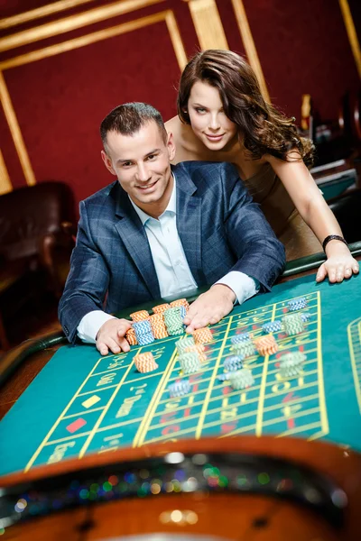Uomo accompagnato da donna al tavolo della roulette — Foto Stock