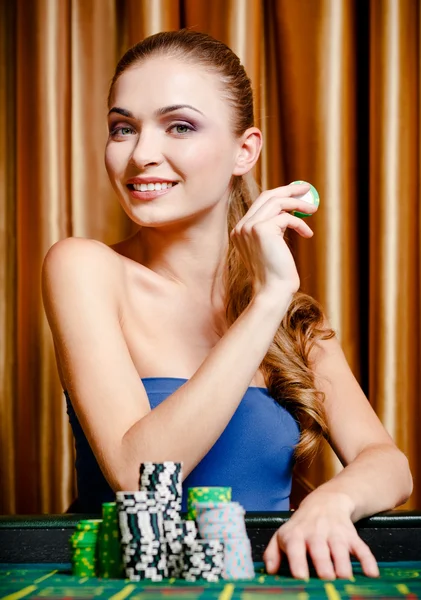Vrouwelijke gokker aan de tafel spelen — Stockfoto