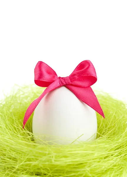 Egg with bow is in the nest of sisal fibre — Stock Photo, Image