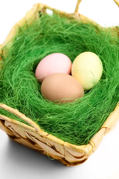 Multicolored easter eggs are in wattled basket — Stock Photo, Image