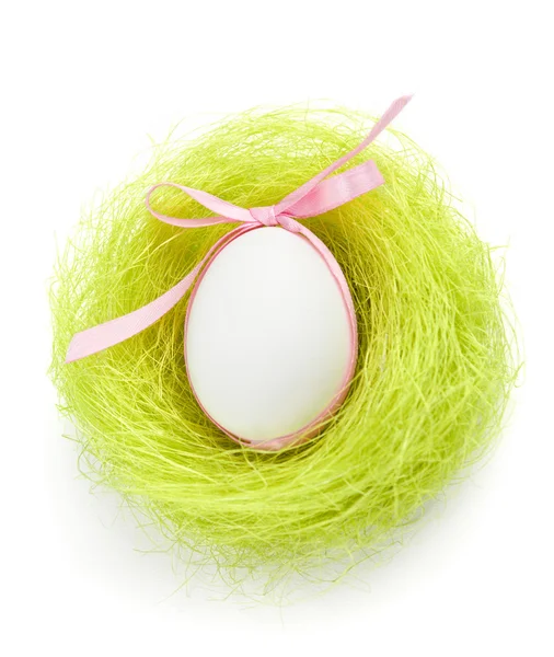 Egg with bow is in the nest of green sisal fibre — Stock Photo, Image