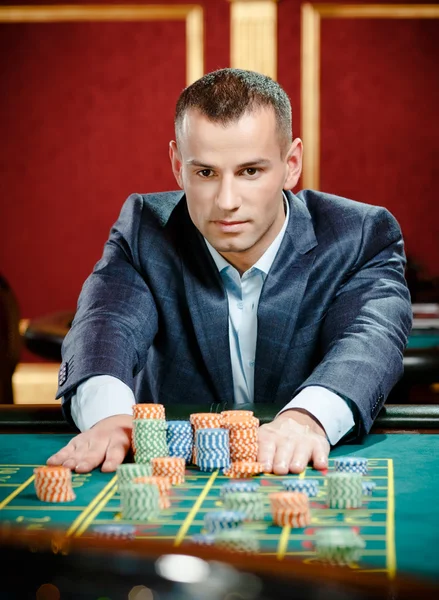 Gambler stakes piles of chips at the casino table — Stock Photo, Image