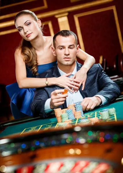 Pige omfavne gambler ved roulette bordet - Stock-foto