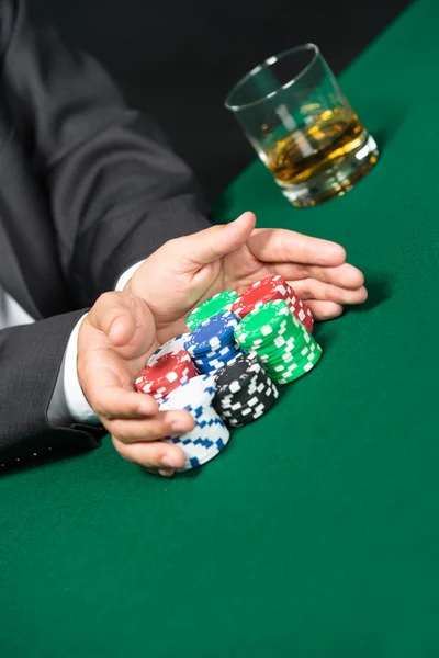 Mand spiller går "all in" skubber sine poker chips fremad - Stock-foto