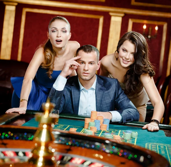 Man with two girls playing roulette at the casino club | Stock Images Page  | Everypixel