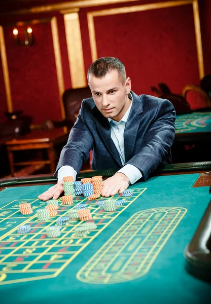 Gambler stakes piles of chips at the roulette table — Stock Photo, Image