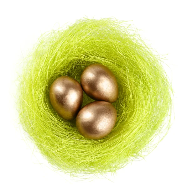 Золотые яйца в гнезде из сизального волокна — стоковое фото