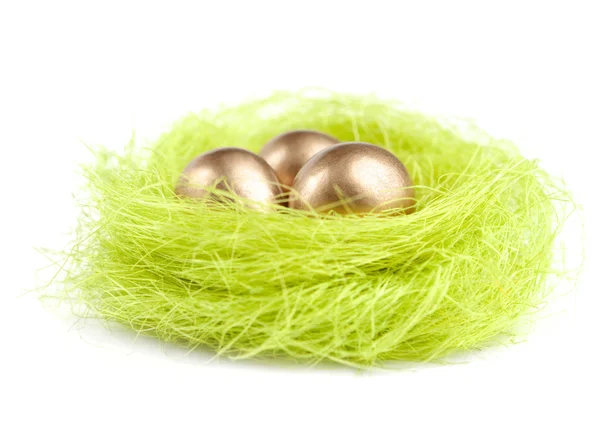 Golden eggs are in the nest of sisal material — Stock Photo, Image