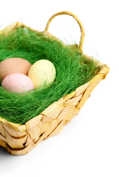 Colored easter eggs are in braided basket — Stock Photo, Image