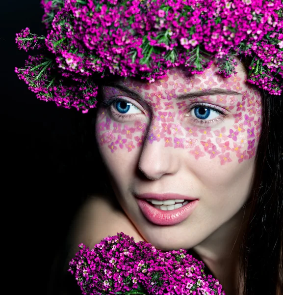 Close-up van blauwogige vrouw met bloemen — Stockfoto