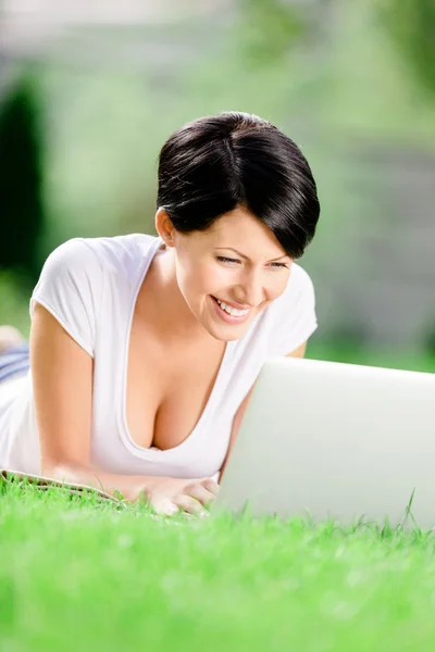 Girl lying on the grass works at the pc — Stock Photo, Image
