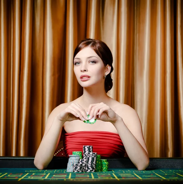 Female gambler sitting at the casino table Stock Picture