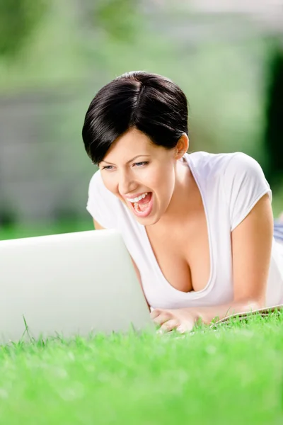 Femeia întinsă pe iarbă lucrează la laptop — Fotografie, imagine de stoc