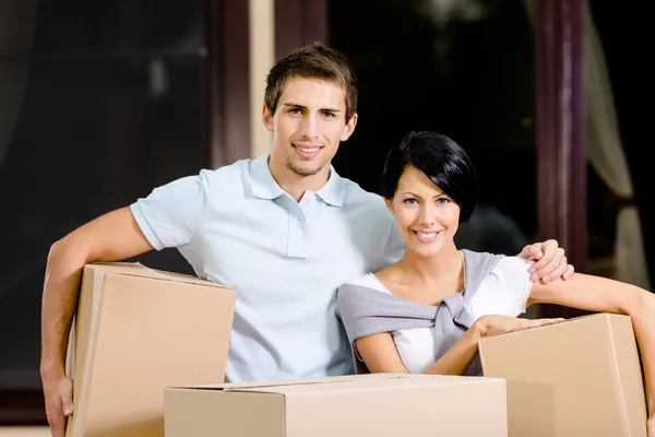 Happy couple carrying pasteboard containers — Stock Photo, Image