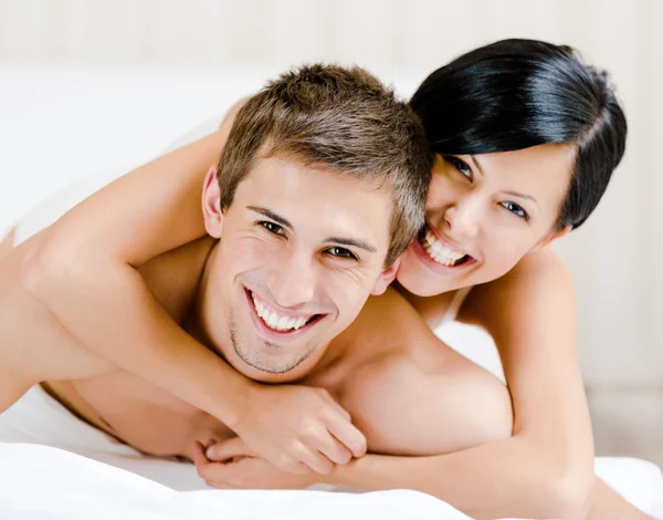 Close up of laughing couple who plays in bed-room — Stock Photo, Image