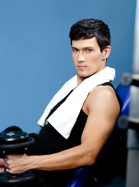 Athletic man rests handing a weight in the hand — Stock Photo, Image