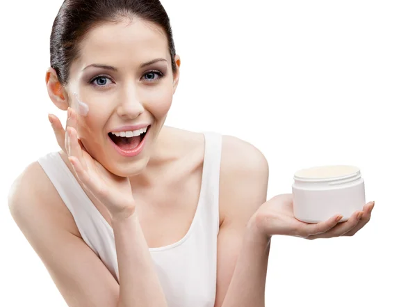 Woman putting on emollient cream from container on face — Stock Photo, Image