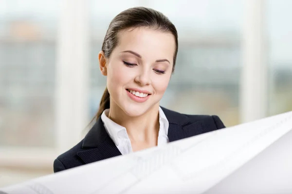 Female engineer looks through the blueprint — Stock Photo, Image