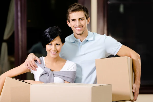 Happy couple carrying cardboard packages — Stock Photo, Image