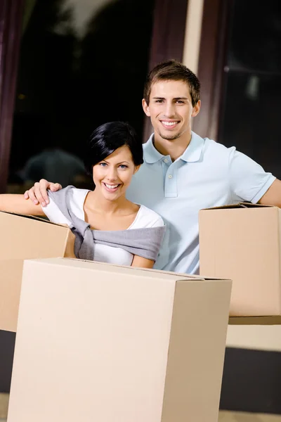 Happy couple carrying pasteboard packages — Stock Photo, Image
