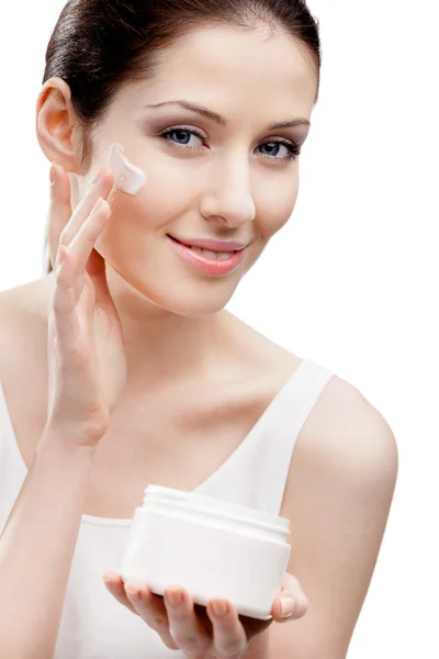 Woman applying lifting cream from container on face — Stock Photo, Image