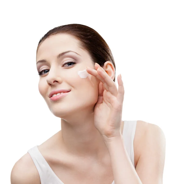 Woman putting on cream on her face — Stock Photo, Image