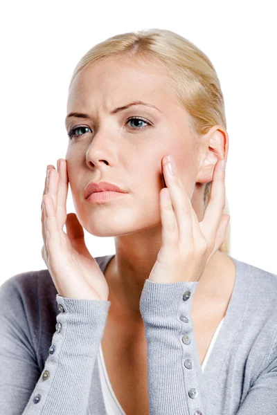 Woman examining her face and wrinkles that can appear, isolated on white