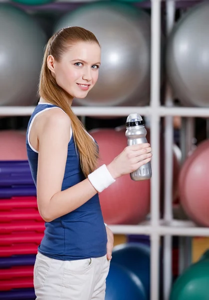 Mujer atlética joven en ropa deportiva sostiene una botella de agua — Foto de Stock